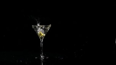 Bir bardak martiniye düşen iki zeytin. Yavaş çekim