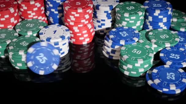 Фишки для покера закатились в казино на черном фоне. Медленное движение — стоковое видео