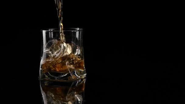 Whiskey se nalévá do sklenice na černém pozadí. Výstřel naslepo. Zpomalený pohyb. — Stock video