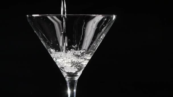 Martini hogy öntenek egy pohár fekete háttér. Lassított mozgás. — Stock videók