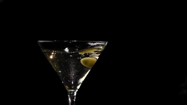 Bir zeytin martini bardağına düşer. Yavaş çekim — Stok video