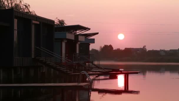 Haus bei Sonnenuntergang auf dem Wasser — Stockvideo