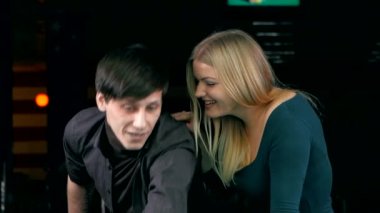 Young couple playing pool in entertainment center.