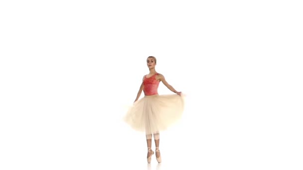 Chica joven girando y bailando ballet, sobre fondo blanco, cámara lenta — Vídeo de stock