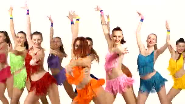 Chicas bailando sincrónicamente en vestidos de colores sobre fondo blanco . — Vídeo de stock