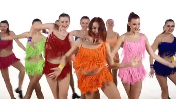 Pretty Girls beyaz arka plan üzerinde renkli elbiseler senkronize dans. yavaş çekim — Stok video