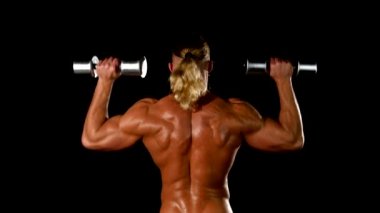 Adam halter yapar. Spor, güç, halter, gerginlik, egzersiz. Fitness ve spor hakkında makale. Spor salonu ve fitness konsepti - vücut geliştirmeci ve siyah üzerinde dumbbell.