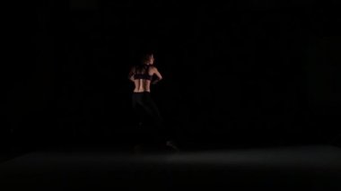Siyah arka plan, yavaş hareket üzerinde gölgede çağdaş dans sportif kız