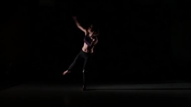 Güzel kız siyah arka plan, yavaş hareket üzerinde gölgede yuvarlak dans tetemp uçar