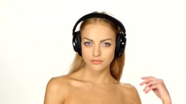 Beyaz gömlekli seksi kadın dinliyor ve kulaklık kullanarak müzik için dans ediyor