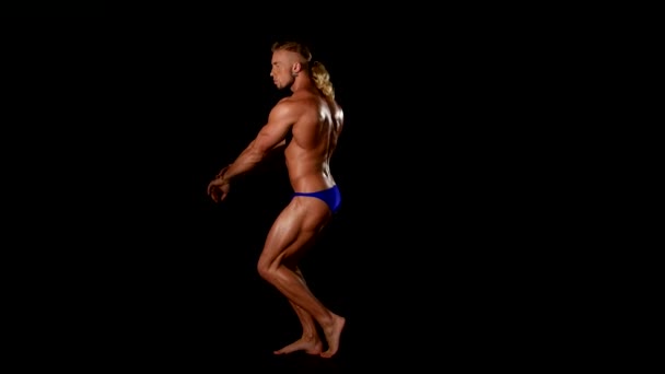 Bodybuilder gespierd op zwarte achtergrond — Stockvideo