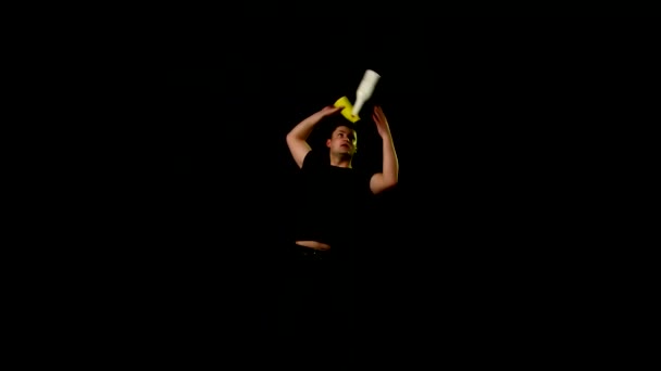 Young man making cocktails with a yellow shaker on black — Stock Video