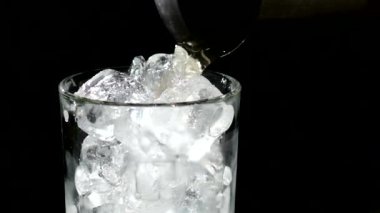 Bir bardak suya düşen bir buz küpü. yakın kapatın. yavaş çekim