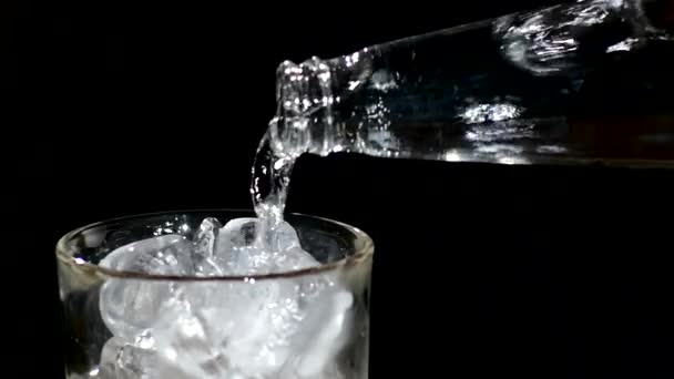 glace tombant dans un verre d'eau. de près. au ralenti 