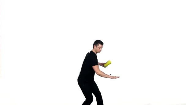 Jeune homme barman fait un tour avec un shaker 