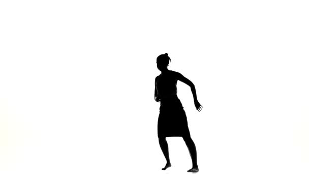 Beautiful dancer woman starts dancing social latino dance barefoot, on white, silhouette