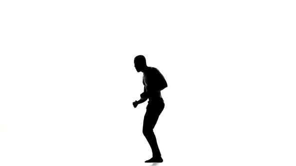 Aantrekkelijke, goede man danser genieten dansen grote sociale Latina dans op wit, Slow Motion, silhouet — Stockvideo