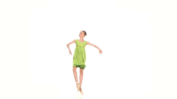 Pequeña bailarina en vestido verde posando sobre un blanco — Vídeo de stock