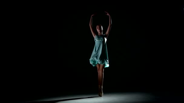 Liten ballerina poserar i blå klänning på svart — Stockvideo
