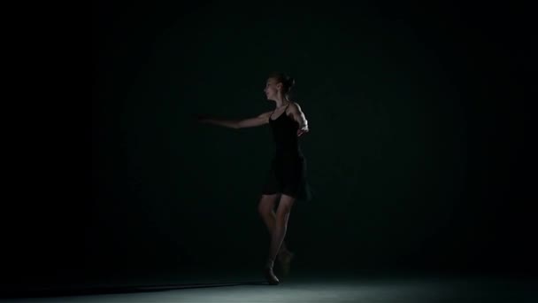 Μπαλαρίνα στην αίθουσα μπαλέτου στα μαύρα. αργή κίνηση — Αρχείο Βίντεο