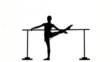 Balerin, bale barresinde poz veren sivri bir şekilde. Siluet. yavaş çekim