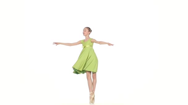 Ballerina in groene jurk die zich voordeed op een wit. Slow motion — Stockvideo