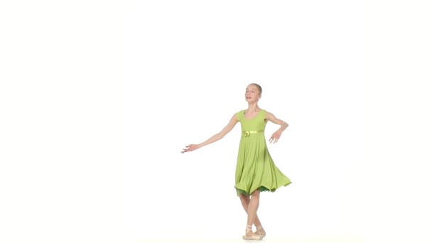 Weinig Ballerina in groene jurk die zich voordeed op een wit. Slow motion — Stockvideo