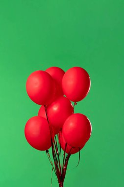 Birçok kırmızı balon krom anahtar efektli yeşil ekrana karşı havada asılı duruyor. Işık yansıtmalı parlak helyum balonlarını kapatın. Doğum günü, parti dekorasyonu, tatil, sürpriz, hediye, geçmiş.