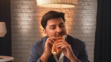 A businessman in a suit enjoys a delicious shawarma in a cozy cafe. An office worker relaxes and eats fast food during his lunch break.