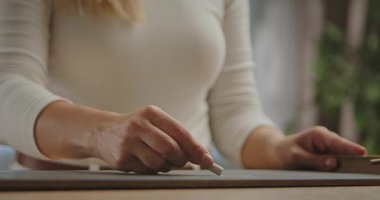 Tebeşirle yazı yazmaya hazır bir kadın eli ile yakından çekilmiş bir görüntü. Yavaş çekim.