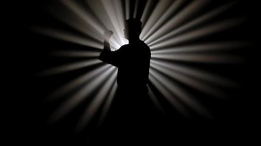 Bir dövüş sanatları ustasının karanlık figürü yeteneklerini geliştirir. Güçlü beyaz bir ışığın önünde çeşitli duruşlar sergiler. Radyasyon ışınları oluşturur..