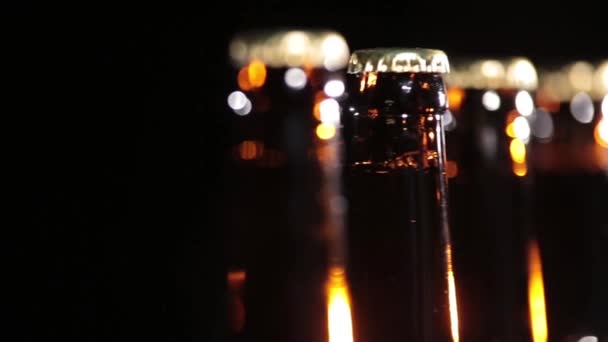 Холодные бутылки пива на черном фоне — стоковое видео