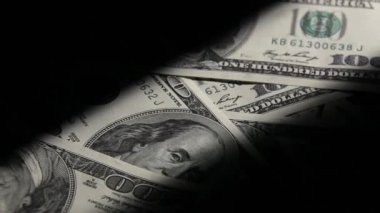 Yüz dolarlık banknotlar makro bir karanlık odada.