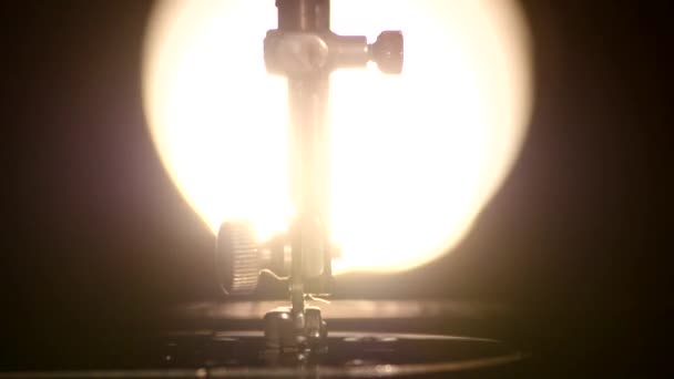 Часть антикварной рабочей серебристой швейной машины, задний свет — стоковое видео