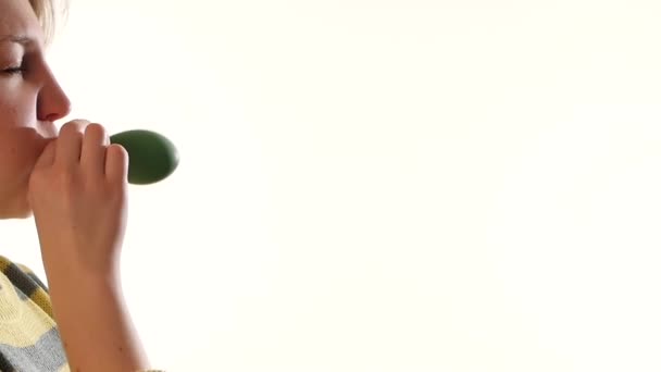 Девушка дует зеленый шарик изолирован на белом фоне, замедленная съемка — стоковое видео
