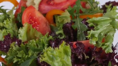 Taze karışık sebze salata üzerine beyaz izole kase içine düşme. Ağır çekim.