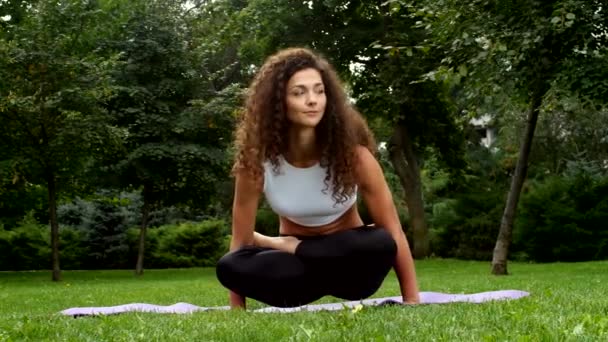 Belle femme pratiquant le yoga dans le parc — Video