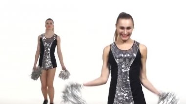 Ellerinde ponponla dans eden iki kız. beyaz arka plan, yavaş çekim, kameraya gülümseyen