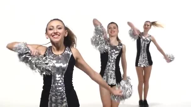Chicas en traje negro con pompones bailando en concursos de animadoras, sonriendo a la cámara, cámara lenta — Vídeos de Stock