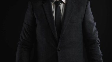 Resmi siyah takım elbiseli ve kravatlı birini yakından çek, profesyonellik ve zarafeti yansıt..