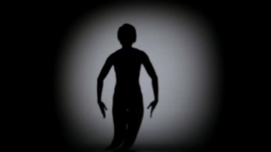 Kız siyah arka plan üzerinde tefeksu gölgesinde hareket, spot ışık