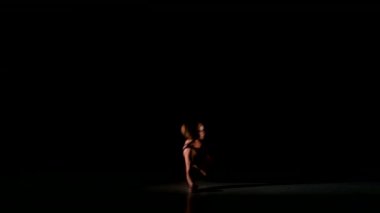Siyah arka planda gölge tetemp kız dansları, spot ışık