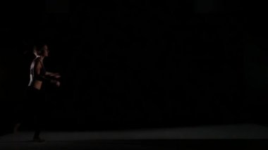 Siyah arka plan üzerinde gölgede contemp dans jumping kız, yavaş hareket