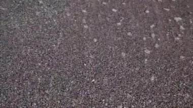 Kristal dalgalar sabah ları deniz kıyısında ıslak kumda yıkanıyor.