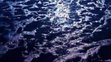 Gece sahilde yürüyen kişi