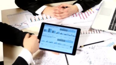 İşadamları grafiklerdeki bilgileri göz önünde bulundurur, anlaşma yapar, bir iş projesi geliştirir ve piyasa veri bilgilerini analiz