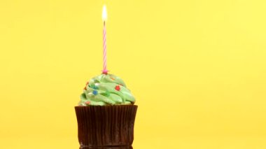 sarı arka plan üzerinde tek bir mum ile lezzetli doğum günü kek