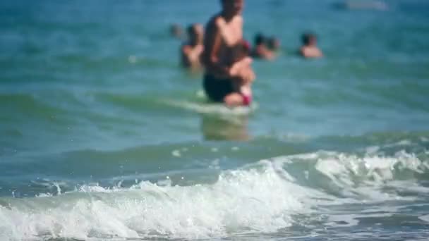 Padre e hija jugando en el agua azul del mar mientras las olas — Vídeo de stock