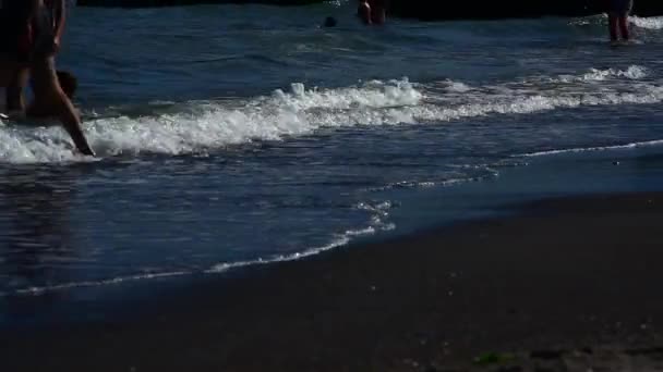 Люди купаются в море на закате — стоковое видео