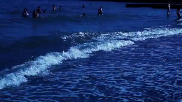 Mensen zwemmen in blauwe zee golven terwijl de nacht, zwarte zee — Stockvideo